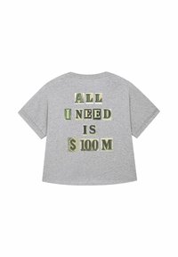 T-shirt oversize grigio con testo audace sul retro: "TUTTO CIÒ CHE MI SERVE È $100 M," con grafiche di banconote integrate nel lettering.