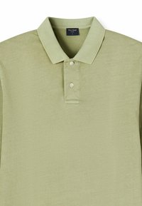 Light green polo shirt made of soft fabric, featuring a three-button placket, collar, and short sleeves. Smooth texture with subtle sheen.