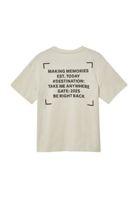 T-shirt en coton couleur crème à manches courtes. Texte au dos comprenant « Making Memories », des hashtags et des informations liées au voyage en noir gras.