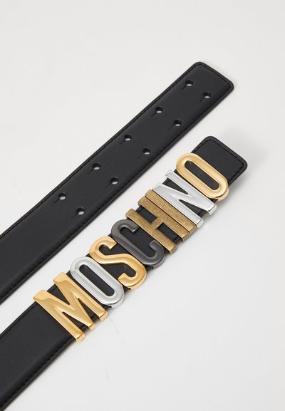 Sort læderbælte med store metalliske bogstaver, der staver "MOSCHINO" i guld, sølv og gunmetal-finish, med synlige justeringshuller.