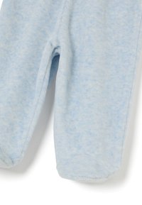Tutina per bambini in pile morbido di colore azzurro chiaro con gambe lunghe, design con piedini e una texture leggermente screziata. Nessuna chiusura o motivo visibile.
