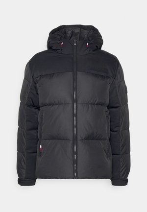 Casaco puffer preto com fecho na frente, capuz e textura acolchoada. Apresenta detalhe de marca no peito e realces contrastantes nas mangas.