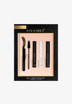 Tool kit featuring five products: black lash applicator, fluffer brush, and various sealers and removers in black and white tubes. Gold accents.