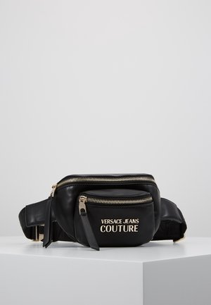 Sort læder bælletaske med guld lynlåse og "Versace Jeans Couture" logo på frontlommen, vist på en hvid overflade.