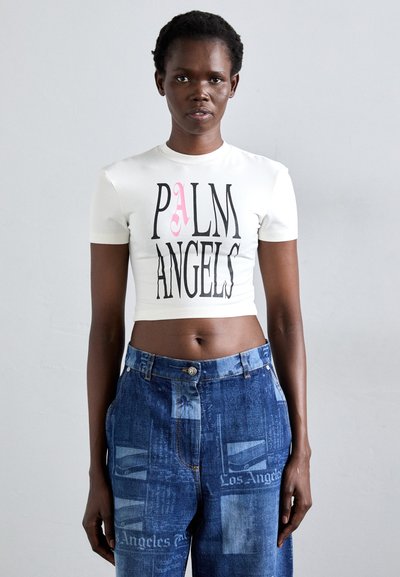 Biały krótki t-shirt z logo "PALM ANGELS" w czerni i różu, zestawiony z niebieskimi jeansami z wysokim stanem, charakteryzującymi się różnymi fakturami i nadrukami denimu.