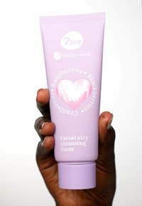 Gezichtsreinigingsschuim in een lavendelkleurige tube, met een reliëf hartontwerp. Tekst omvat "Frambozen," "Bramen," en "Cranberry's."