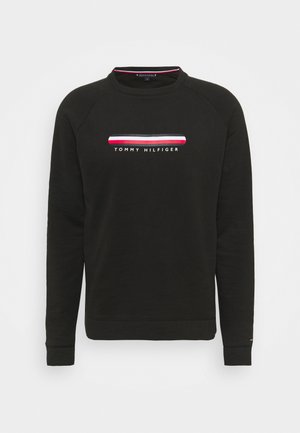 Svart sweatshirt med rund halsringning och långa raglanärmar. Har en vit, röd och blå randig logotyp över bröstet. Mjuk tyg.