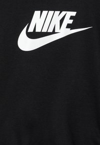 Czarny bawełniany t-shirt z dużym białym logiem Nike na piersi. Miękka tekstura z klasycznym okrągłym dekoltem.