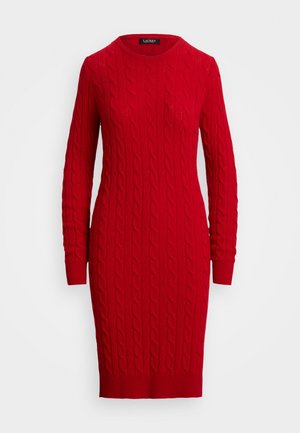Rochie pulover tricotată cu cabluri roșii, cu mâneci lungi, guler tip echipaj și manșete și tiv cu striații, prezentată pe un fundal alb.