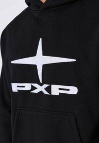 Zwarte hoodie met een grote witte ster graphic en "PXP" tekst. Het materiaal lijkt zacht; heeft een vrolijk voorvak.