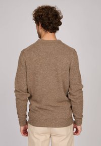 Pull en tricot marron avec une finition légèrement texturée. Conception à col rond et manches longues. La vue de dos montre des poignets et un ourlet côtelés.