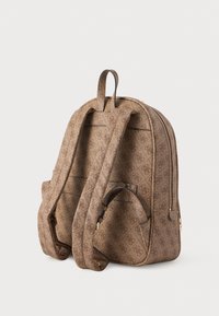 Zaino marrone a patter con chiusura a zip, spallacci regolabili e cuciture visibili. Presenta una finitura testurizzata e accenti in metallo color oro.