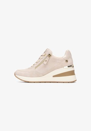 Zapatillas beige con tacón cuña, paneles de tela texturizada, detalles en hardware dorado y cierre lateral con cremallera para un fácil uso.