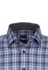 Camicia a quadri con tonalità blu, bianco e nero. Collo con bottoni e una texture interna liscia. Etichetta del marchio visibile all'interno del collo.