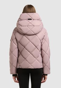 Lyserød quiltet pufferjakke med en stor hætte, der har et diamantmønster og elastiske manchetter. Bagsiden viser et slankt design uden synligt hardware.