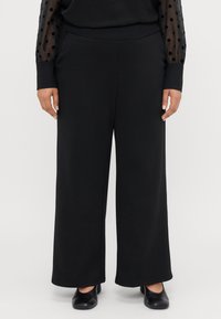 Szerokie czarne spodnie wykonane z miękkiego materiału o gładkiej fakturze, z wysokim stanem i prostym fasonem.