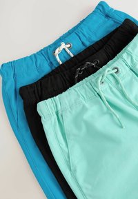 Tre paia di pantaloni corti: blu brillante, neri e verde menta. Materiale leggero con vita elastica e dettagli con coulisse.