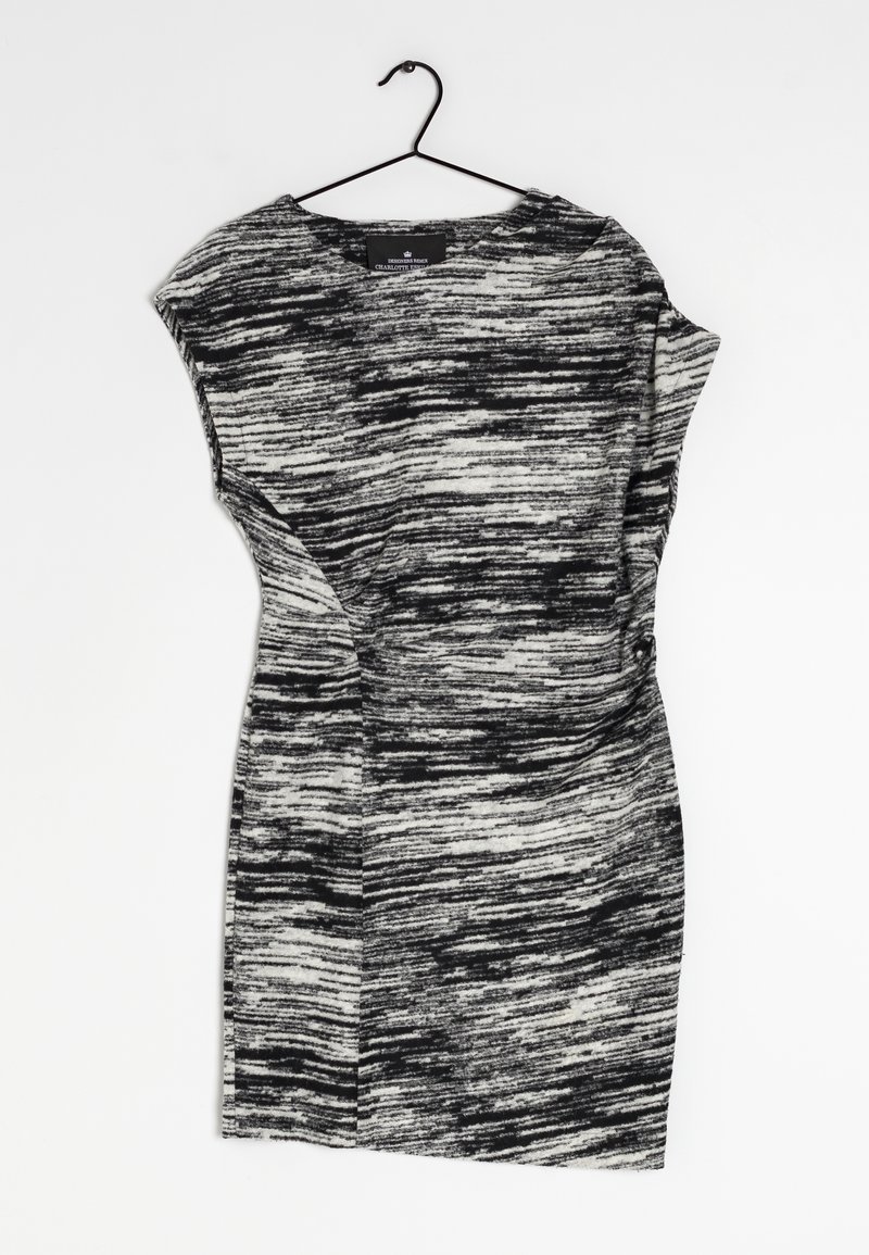 Schwarz-weißes Kleid, das an einem Haken hängt, mit einem strukturierten, abstrakten Muster, kurzen Ärmeln und einer taillierten Form.