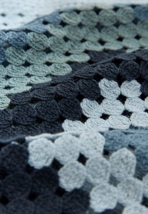 Pătură tricotată, cu model texturat în nuanțe de albastru, gri și negru; motive circulare și detalii intricate croșetate.