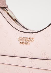 Borsa a tracolla in pelle rosa embossata con finiture in tonalità oro, dotata di chiusura con zip e accento con logo. Texture liscia e forma strutturata.