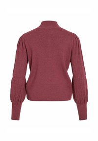 Pull maroon avec un col haut, un corps ajusté et des manches bouffantes texturées avec des détails en tricot irlandais. Tissu doux avec une texture lisse.