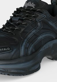 Αθλητικό παπούτσι της μάρκας Black Buffalo με παχιά σόλα, μαύρα και γκρι κορδόνια και υφασμένους πίνακες στο πάνω μέρος.