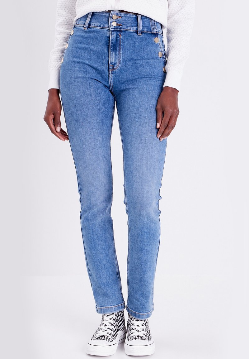 Jean en denim bleu taille haute avec une coupe slim, arborant des accents de boutons dorés et un design à cinq poches. Texture : lisse avec un léger élasticité.