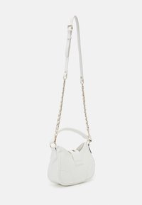Petit sac à main en cuir blanc avec chaîne dorée et bandoulière ajustable, présentant une poignée supérieure et une fermeture à bouton.