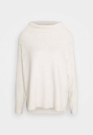 Pull beige clair avec un col côtelé haut, des épaules tombantes et un ourlet côtelé. Texture douce avec une coupe décontractée et une silhouette ample.