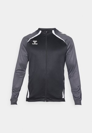 Chaqueta atlética negra y gris con cremallera completa, mangas largas y detalles en blanco. Presenta un logo en el pecho y un diseño ajustado.