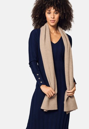 Abito in maglia a coste blu navy con scollatura a V e maniche lunghe, abbinato a una sciarpa morbida beige. Presenta bottoni sulle maniche e una texture liscia.