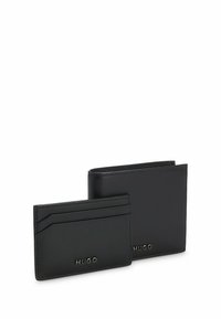 Zwarte leren portemonnee set inclusief een kaarthouder en een bifold portemonnee. Voorzien van een gegraveerd logo en een gladde textuur met nette stiksels.