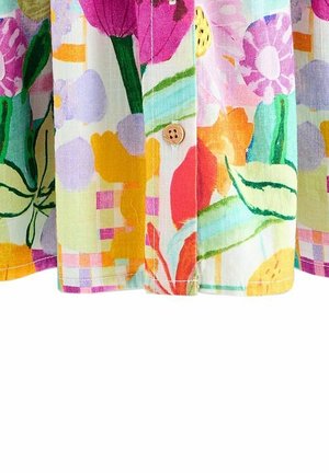 Tela con un colorido estampado floral que presenta tulipanes y diversas flores, con un fondo claro y texturizado, además de un detalle de un solo botón de madera.