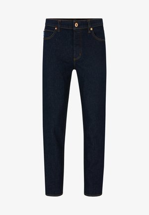 Donkerblauwe denim jeans met een slim fit, contrasterende oranje stiksels en een klassieke knoopsluiting. Voorzien van voorkruiden en taps toelopende benen.