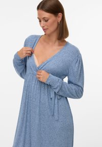 Jasnoniebieska sukienka na długi rękaw z dekoltem w kształcie litery V i paskiem w talii. Miękka, teksturowana tkanina z delikatnymi zakładkami i luźnym krojem.