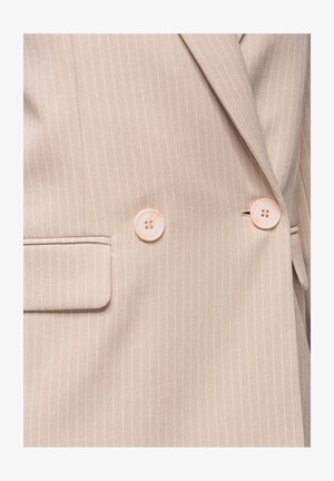 Blazer beige à fines rayures avec deux boutons rose clair et une poche à rabat sur le côté gauche.