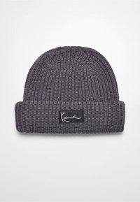 Graue Strickmütze mit Rippenstruktur, versehen mit einem schwarzen Etikett und weißer Signatur. Gefaltete Manschette mit weichem, dicht gewebtem Stoff.