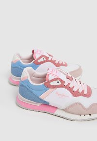 Zapatillas rosas, azules y blancas con una combinación de materiales que incluye ante y malla; acentos texturizados y detalle de logo de la marca en el lateral.