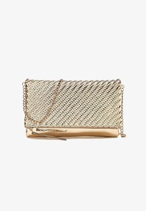 Pochette tissée couleur or avec rabat, détail zippé et fine chaîne dorée attachée sur fond blanc.