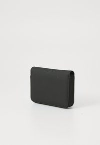 Portefeuille en cuir noir avec une texture lisse, de forme rectangulaire, aux bords arrondis, et une fermeture éclair sur un côté.