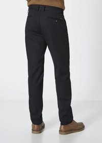 Marineblaues Trousers mit geradem Schnitt, strukturiertem Stoff, zwei Rückentaschen und braunen Schuhen. Minimales Design ohne sichtbare Logos oder Muster.