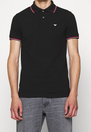 Zwart poloshirt van katoen, met een kraag met rood-wit gestreepte accenten en een klein logo op de borst.
