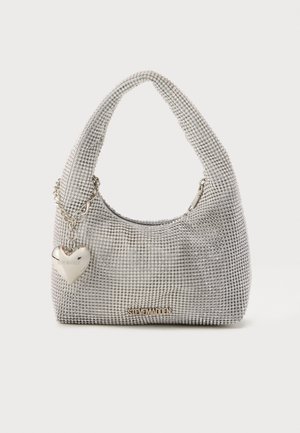 Sac à main argenté orné de strass, avec un charme en forme de cœur et le logo Steve Madden à l'avant, sur fond uni.