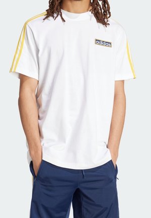 White cotton t-shirt with short sleeves, featuring yellow stripes on shoulders and an embroidered blue Adidas logo on the chest.