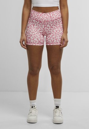 Pink leopard print shorts made of stretchy fabric, featuring a high waistband and flat seams, paired with white athletic sneakers.
