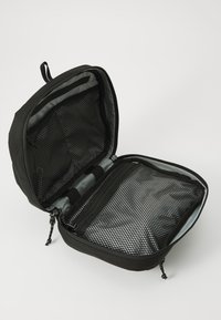 Svart zippered förvaringsväska med meshinteriör, slät foder och fack. Kompakt form, lämplig för att organisera föremål.