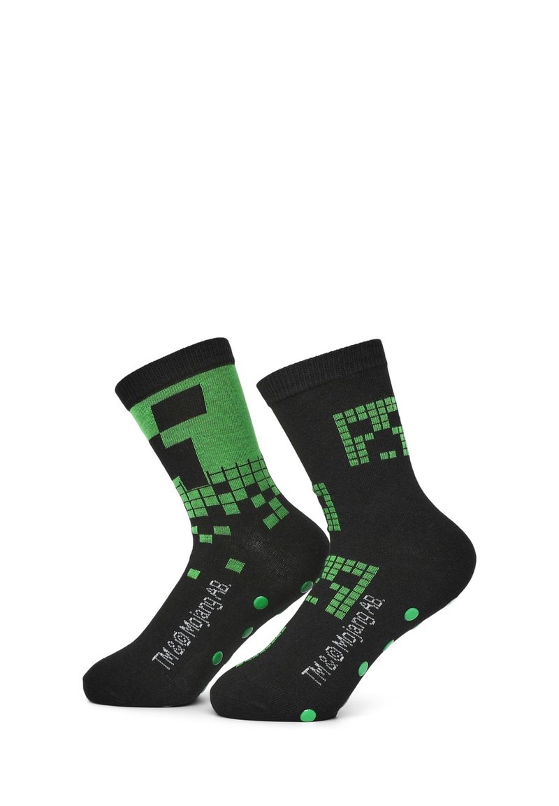 Calze nere con grafiche pixelate verdi, un gambale rinforzato, accenti antiscivolo a pois sulla suola e testo del logo sul lato.