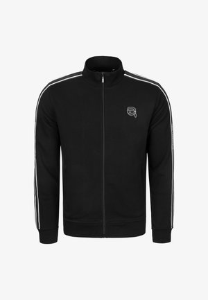 Zwarte jas met ritssluiting van gladde stof en hoge kraag, met witte strepen aan de zijkanten en een geborduurd logo op de borst.