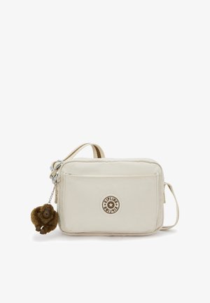 Beige crossbody bag with soft fabric, rectangular shape, zippered closure, and a detachable furry monkey keychain. Features an embossed logo.