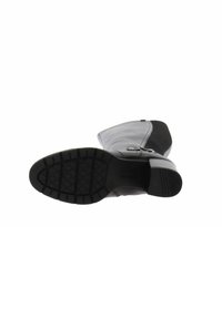Stivaletto in pelle nera con suola in gomma texture, caratterizzato da una punta rotonda, tacco leggero e pannello in tessuto a contrasto nella parte superiore.